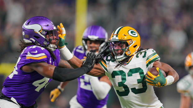 Dec 31, 2023; Minneapolis, Minnesota, USA; Green Bay Packers running back Aaron Jones (33) runs with the ball against the Minnesota Vikings safety Josh Metellus (44) in the first quarter at U.S. Bank Stadium.